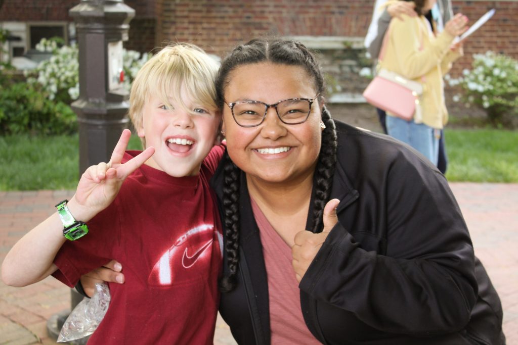 A Hopkins student giving a thumbs up and a tutee giving a peace sign at the 2023 field day